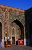 The Registan contains three madrasahs (schools), the Ulugh Beg Madrasah (1417–1420), Tilya-Kori Madrasah (1646–1660) and the Sher-Dor Madrasah (1619–1636).<br/><br/>

The Tilya-Kori Madrasah was built in the mid-17th century by the Shaybanid Amir Yalangtush. The name Tilya-Kori means ‘gilded’ or ‘gold-covered’, and the entire building is lavishly decorated with elaborate geometrical arabesques and sura from the Qur’an both outside and especially within. A magnificent turquoise dome rises over the left (western) side of the building, decorated inside with gilded Qur’anic inscriptions and delicate muqarnas hanging ‘stalactite’ decorations. The interior of the madrasah comprises rooms for students with accompanying vestibules surrounding three-sides of a square courtyard, while a domed mosque occupies the fourth.<br/><br/> 

The dome rises in four stages. A rectangular plinth forms the primary prayer hall and rises above the madrasa walls. Next, two terraced octagonal tiers rise to support a high cylindrical drum. The dome's monochrome blue color contrasts pleasingly with the drum's polychrome decoration formed by bands of Arabic calligraphy taken from the Qur’an.